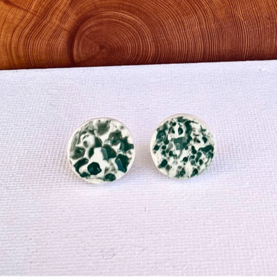 Porcelain sea pebble stud earrings on white canvas background with Forrest green marbled glaze pattern.