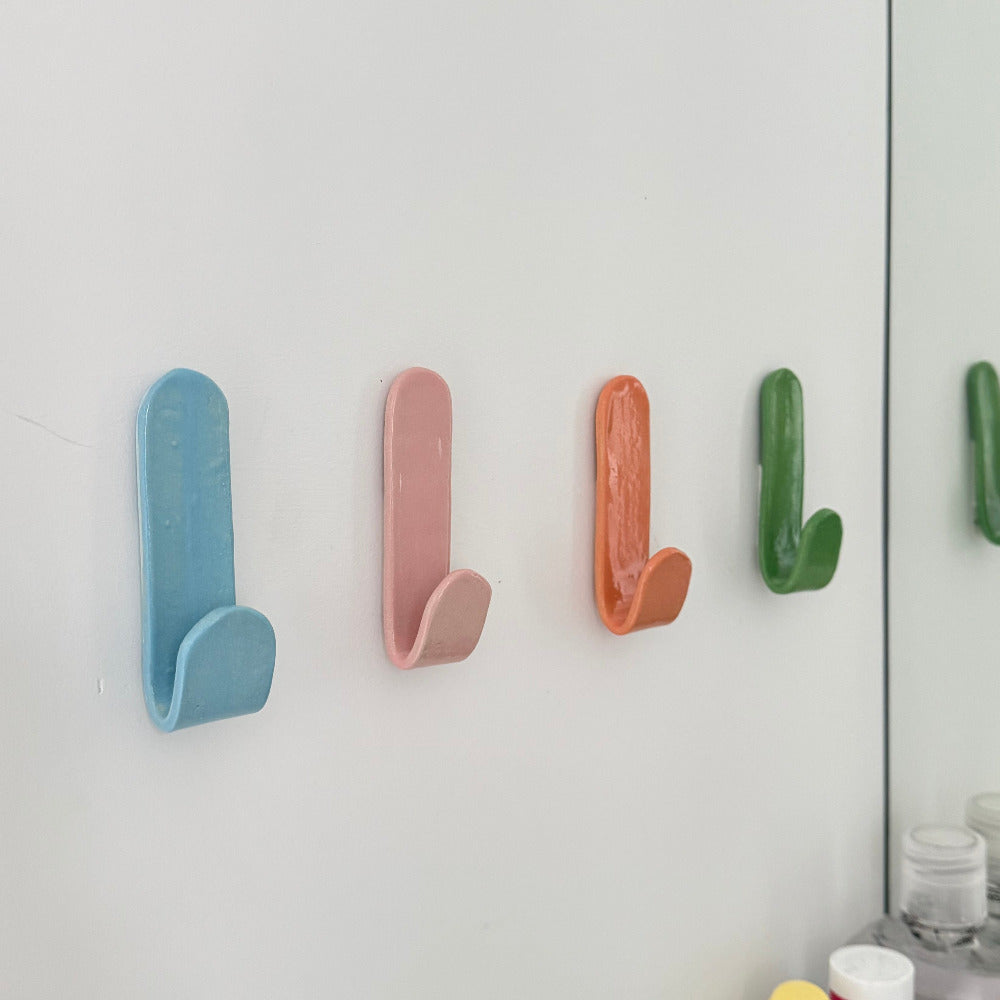 Set of colourful ceramic wall hooks arranged in a row – sustainable handmade homewares by Fields and Seas.