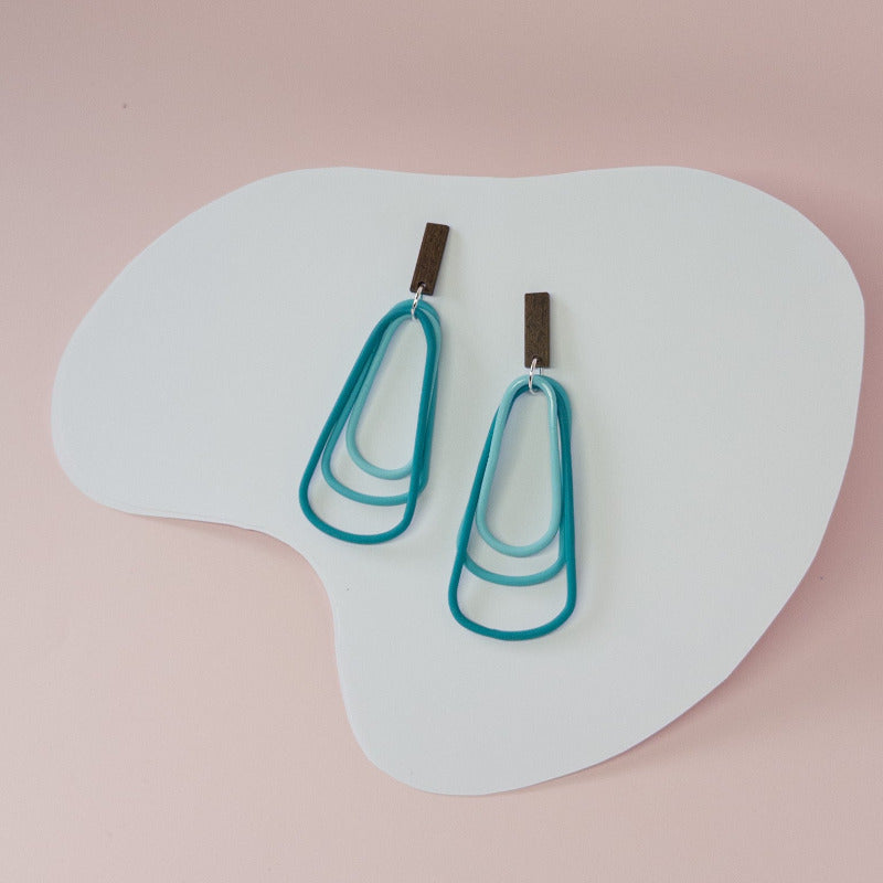 Bold teal dangles that capture the depth and energy of the ocean in every movement.