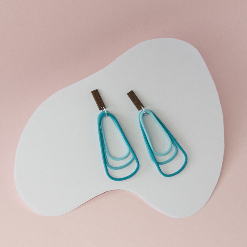 Striking teal layers flow like waves — a statement piece inspired by the sea. Polymerclay dangle earrings.