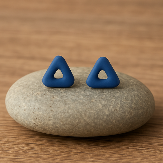 Blue porcelain triangle stud earrings on neutral stone background