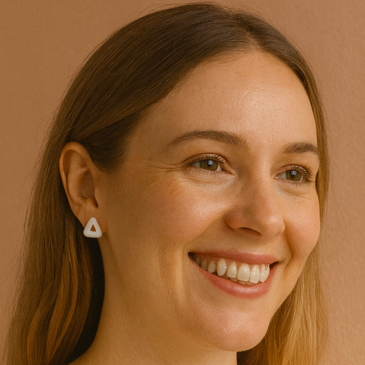 Woman wearing a triangle earring against a beige background