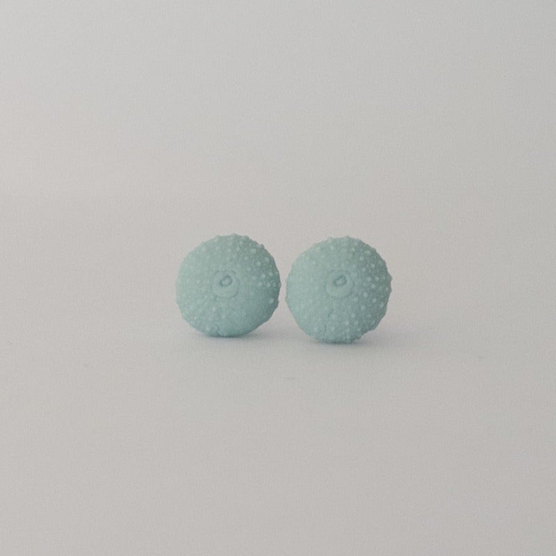 Close-up of handcrafted sea urchin studs in laguna porcelain with textured detail
