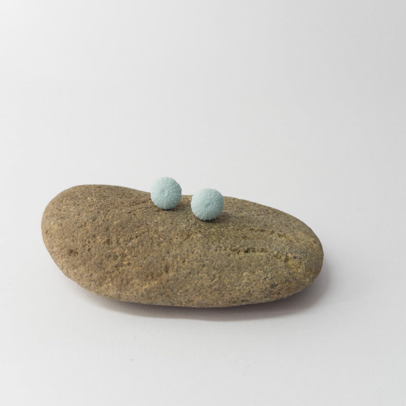 Minimalist ocean jewellery – porcelain urchin stud earrings on display prop
