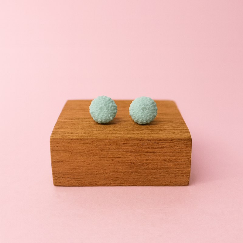 Minimalist ocean jewellery – porcelain urchin stud earrings on display prop
