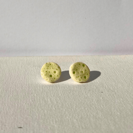 Close-up of handcrafted porcelain stud earrings with sea urchin pattern, 1.5 cm in size, light and durable, inspired by coastal textures. green