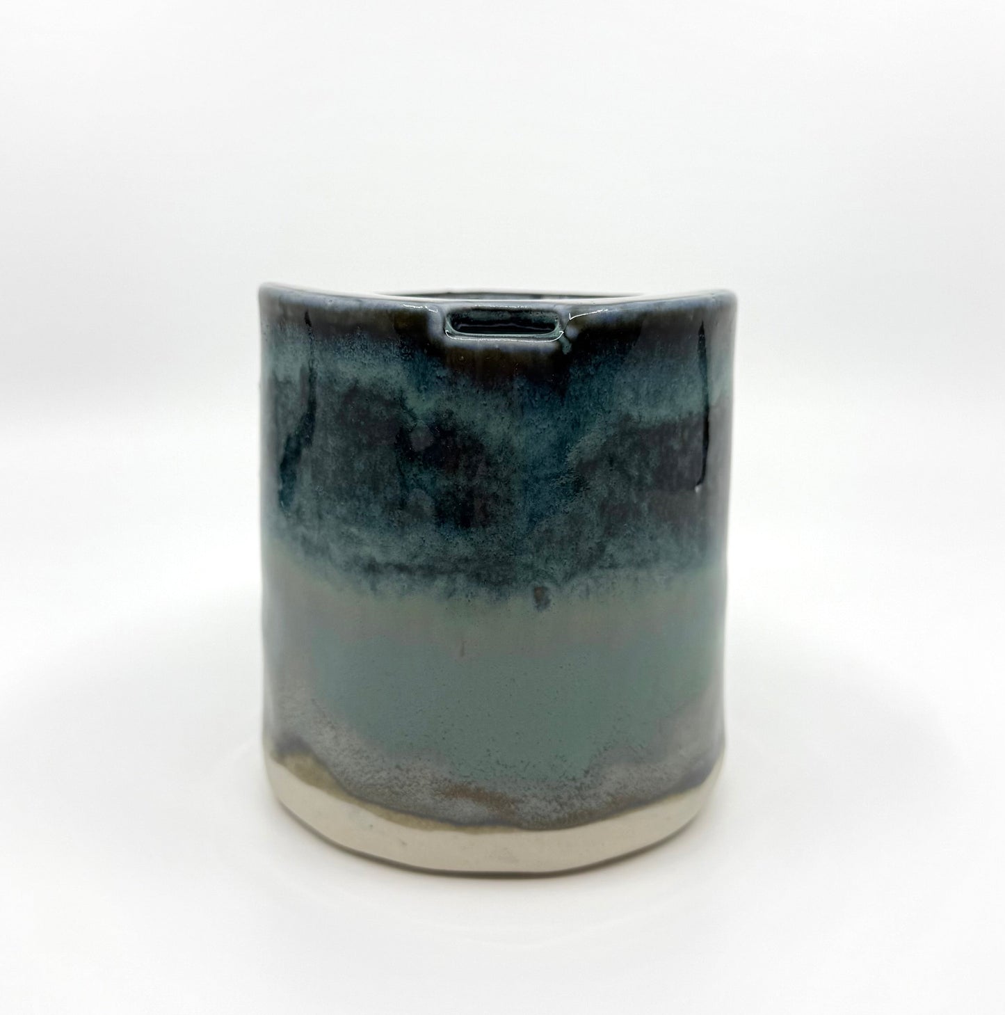Handmade stoneware coffee cup with layered ocean-inspired blue and seafoam glazes, inspired by the deep blue sea and coastal landscapes.