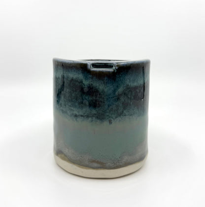 Handmade stoneware coffee cup with layered ocean-inspired blue and seafoam glazes, inspired by the deep blue sea and coastal landscapes.