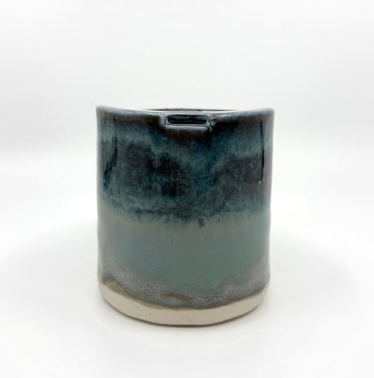 Handmade stoneware coffee cup with layered ocean-inspired blue and seafoam glazes, inspired by the deep blue sea and coastal landscapes.