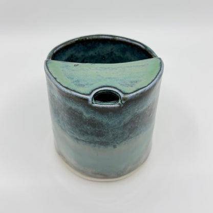Handmade stoneware coffee cup with layered ocean-inspired blue and seafoam glazes, inspired by the deep blue sea and coastal landscapes.