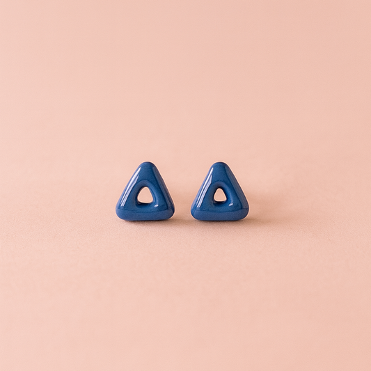 Close-up of shiny cobalt triangle studs with arrow-inspired design