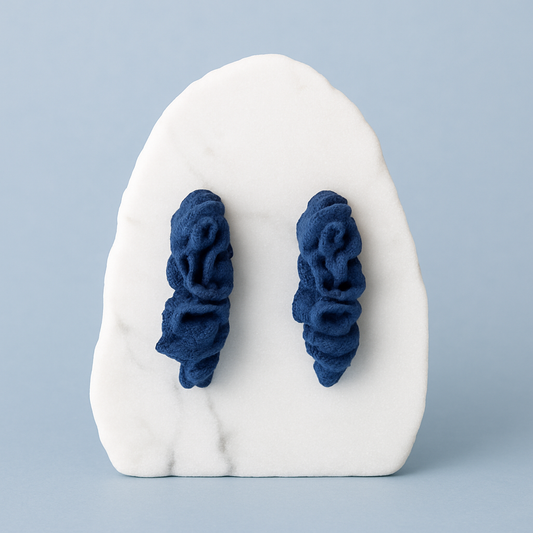 Pair of deep cobalt blue porcelain coral earrings on marble.