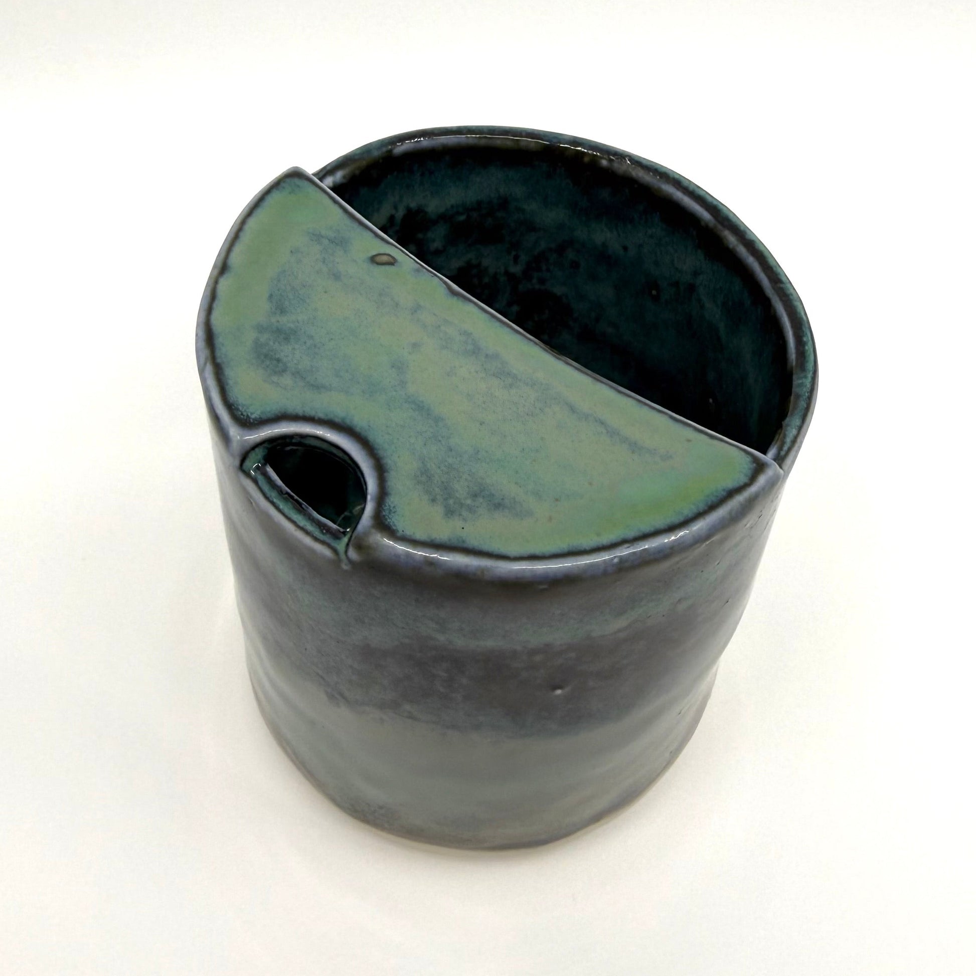 Handmade stoneware coffee cup with layered ocean-inspired blue and seafoam glazes, inspired by the deep blue sea and coastal landscapes.
