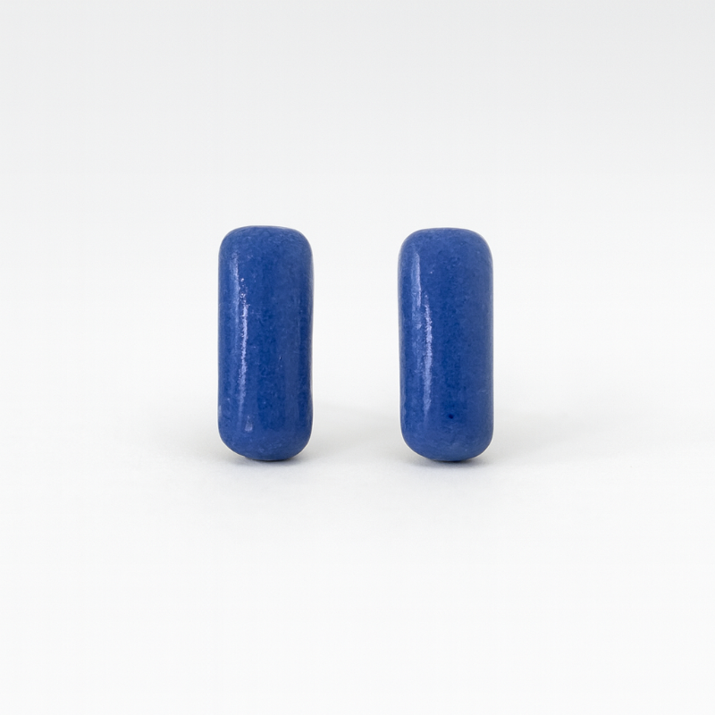 Close-up of cobalt blue porcelain bar earrings with glossy finish