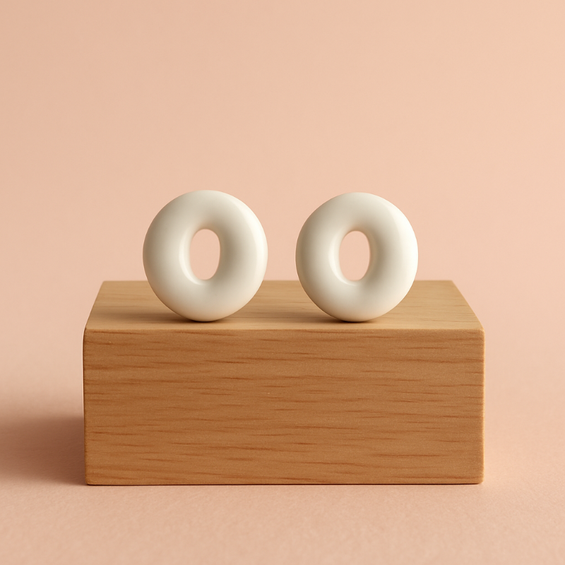 White porcelain stud earrings with clear glaze on wooden prop – handmade by Fields and Seas