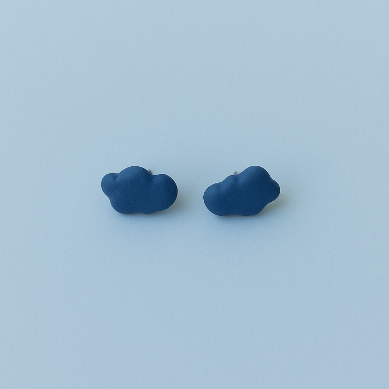 Flat lay of blue porcelain cloud-shaped earrings on a light surface
