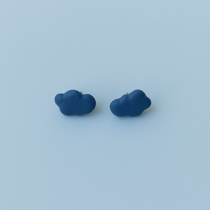 Flat lay of blue porcelain cloud-shaped earrings on a light surface