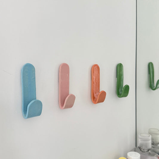 Set of colourful ceramic wall hooks arranged in a row – sustainable handmade homewares by Fields and Seas.