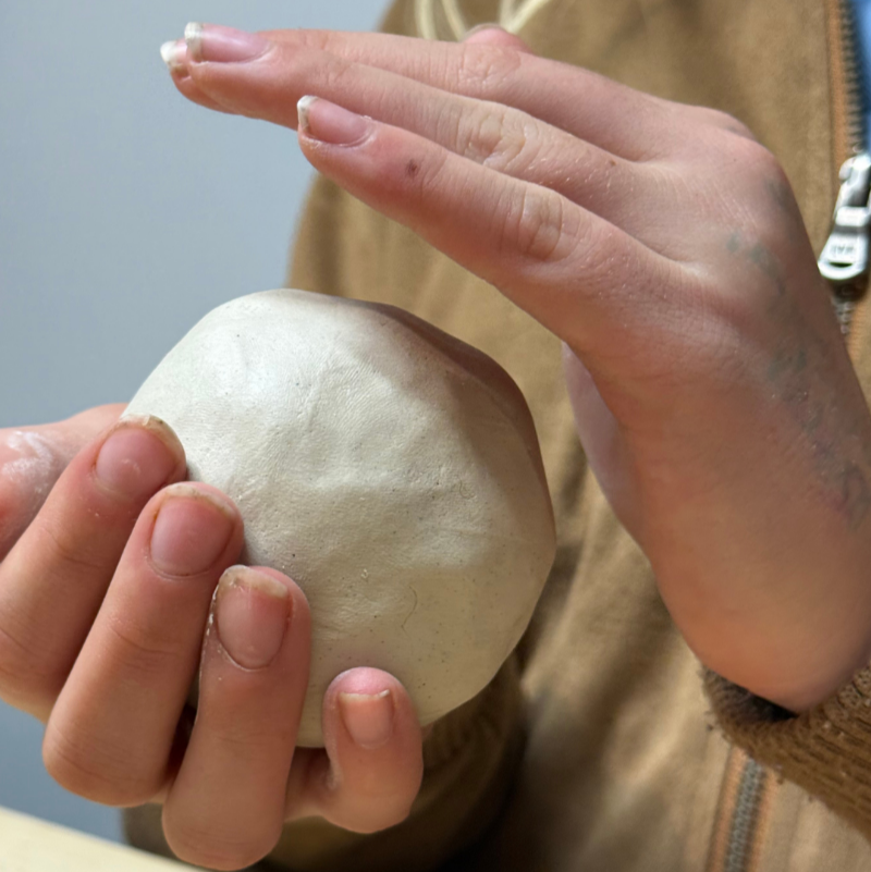 Kids hands shaping clay at workshop