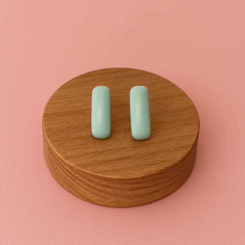 Handcrafted porcelain turquoise blue stud earrings on soft pink background