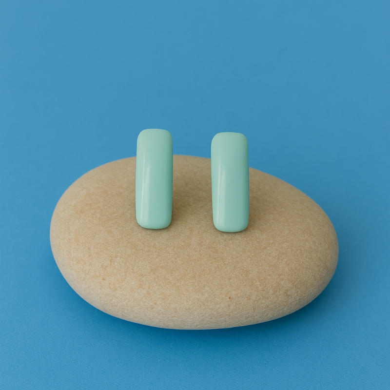 Lagoon Porcelain Blue earrings resting on a river pebble