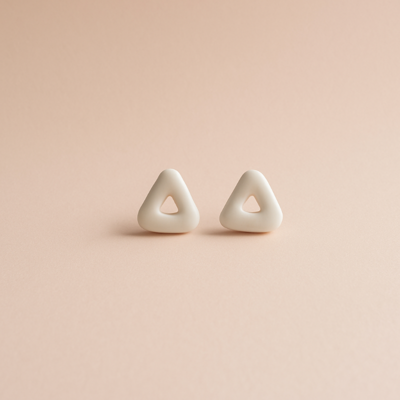 Pair of triangle-shaped earrings on a pink background