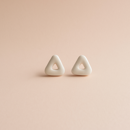 Pair of triangle-shaped earrings on a pink background
