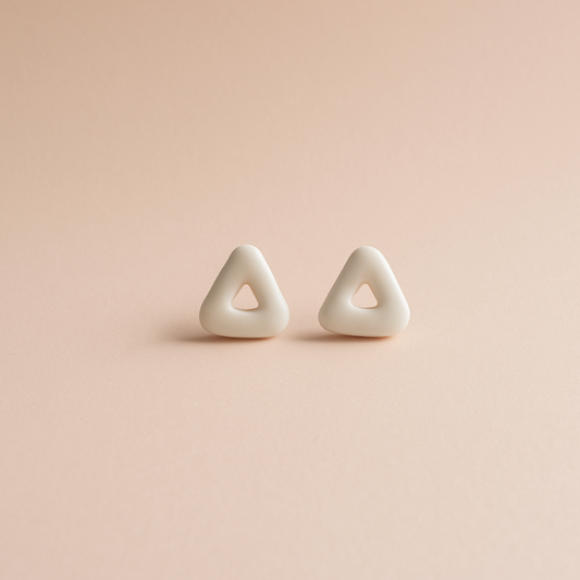 Pair of triangle-shaped earrings on a pink background