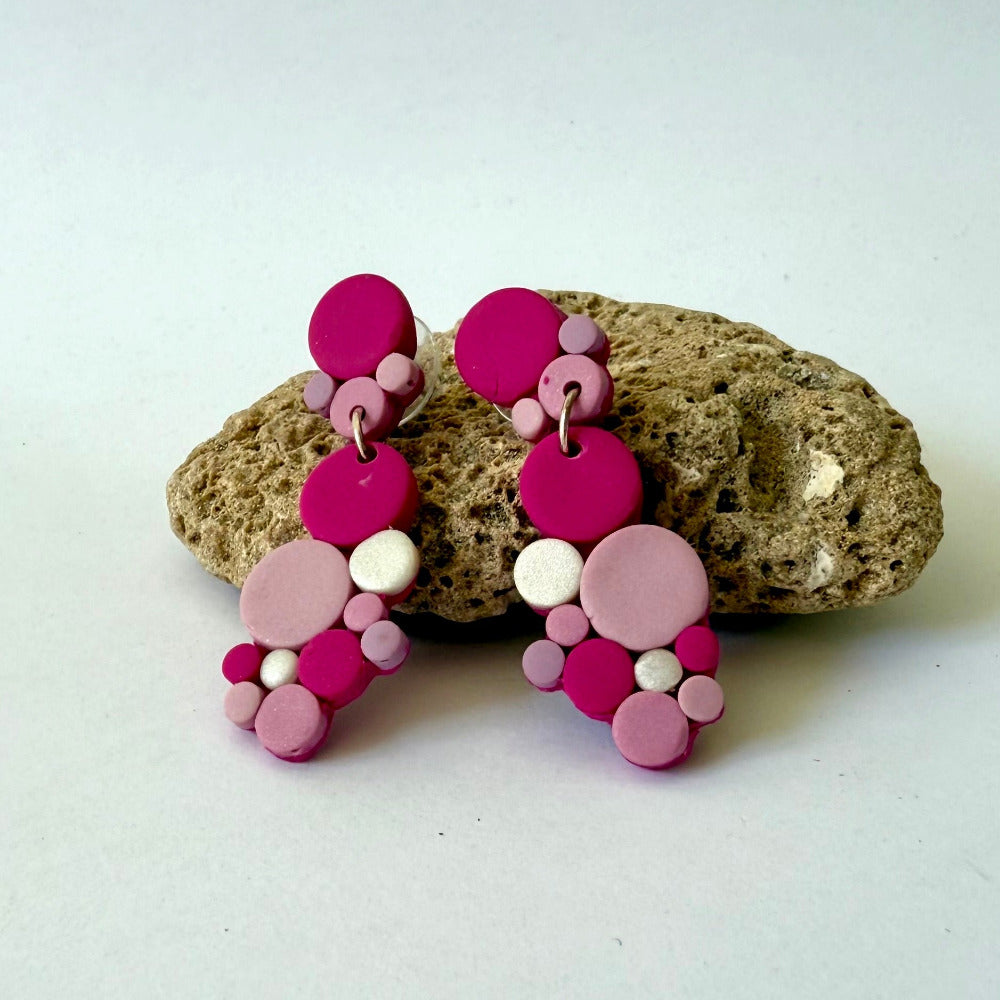 Handmade polymer-clay monochromatic pink bubble clusters with surgical-steel studs, displayed on a light background.