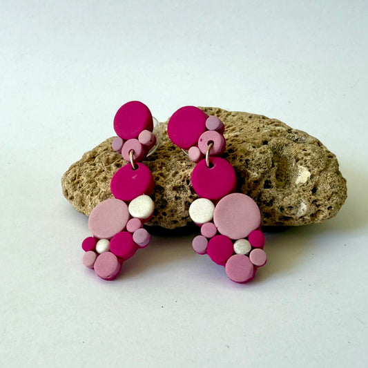 Handmade polymer-clay monochromatic pink bubble clusters with surgical-steel studs, displayed on a light background.