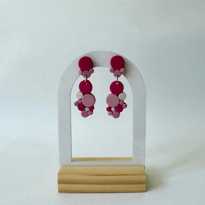 Handmade polymer-clay monochromatic pink bubble clusters with surgical-steel studs, displayed on a light background.