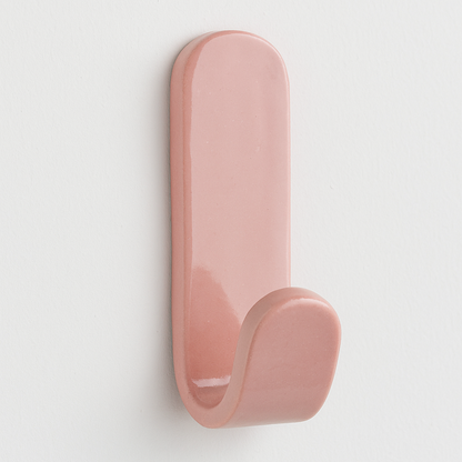 Pink stoneware wall hook on white wall – coastal-inspired handmade bedroom decor.