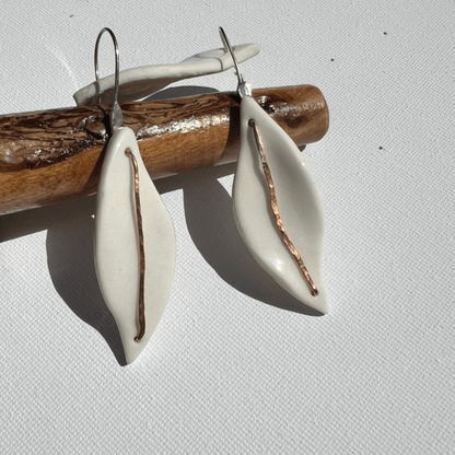 Porcelain earrings named Silverleaves featuring a white ceramic leaf form with hammered copper and sterling silver accents, hanging gracefully at approximately 6 cm in length. Inspired by the coastal beauty of Silverleaves, Phillip Island.