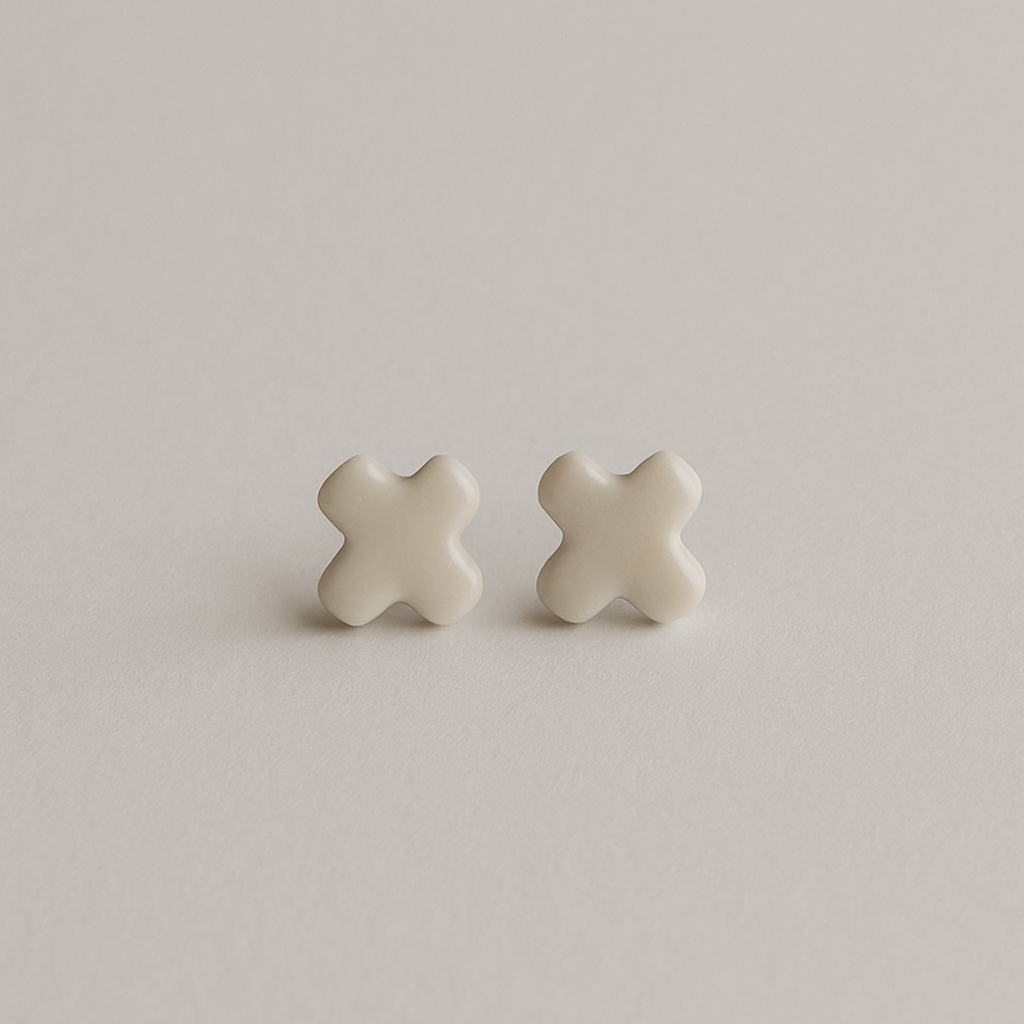 A pair of Tide + Form white porcelain cross stud earrings with a glossy finish, handcrafted and displayed on a clean background.