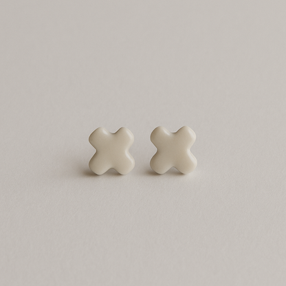 A pair of Tide + Form white porcelain cross stud earrings with a glossy finish, handcrafted and displayed on a clean background.