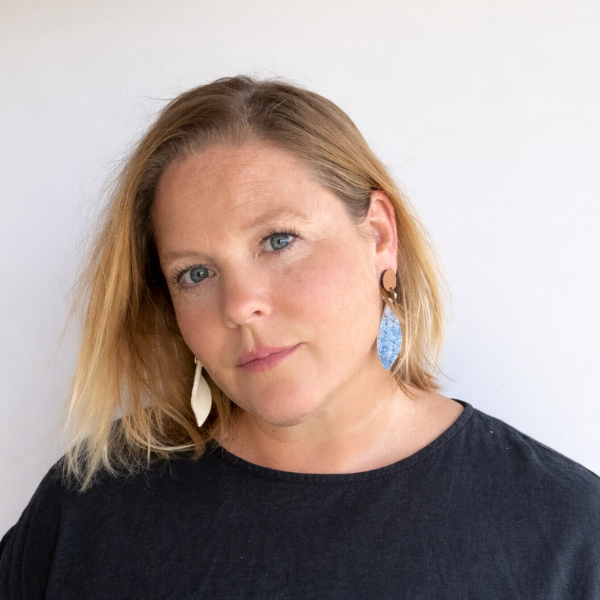 Woman wearing handmade blue porcelain drop earrings inspired by ocean tide textures by Fields and Seas Australia.