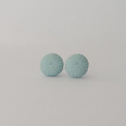 Close-up of handcrafted sea urchin studs in laguna porcelain with textured detail