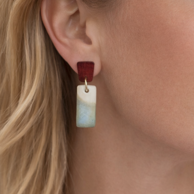 Model wearing porcelain earrings with soft green gradient and natural wood detail