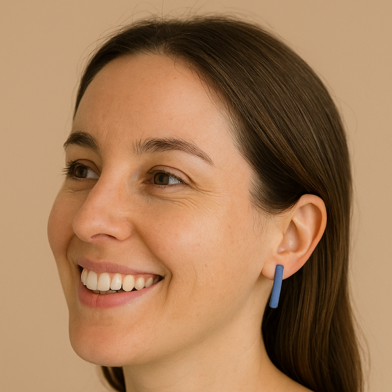 Minimalist long blue porcelain bar earrings on smiling woman.