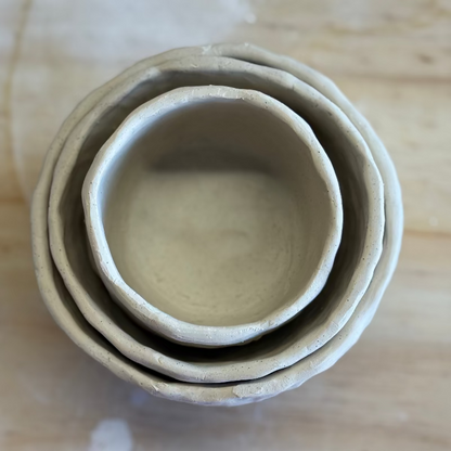 Stack of three ceramic bowls on a wooden surface