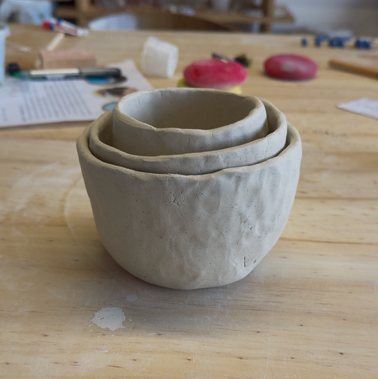 Three ceramic bowls on a wooden surface with a video player interface at the bottom.