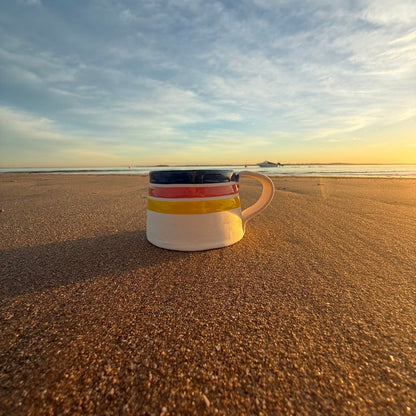 Handmade ceramic mug with blue, red and yellow stripe detail