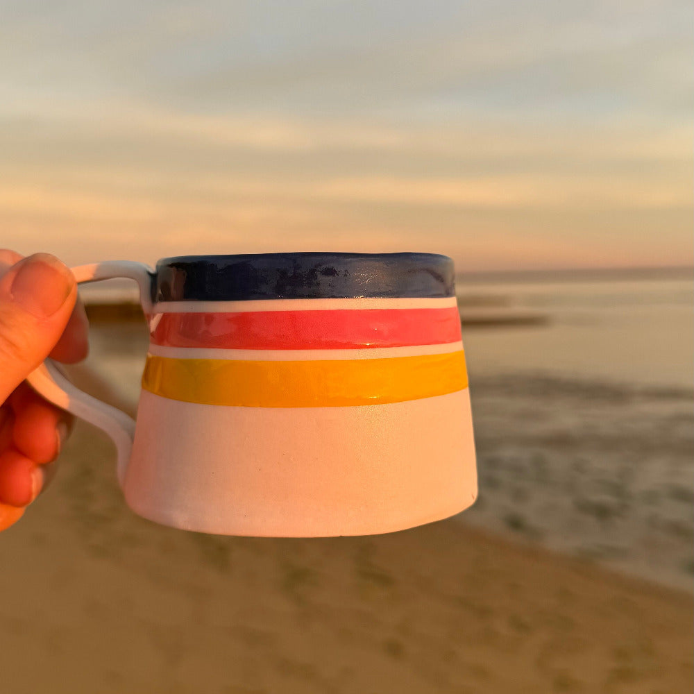 Artisan striped mug with cobalt rim and warm tones