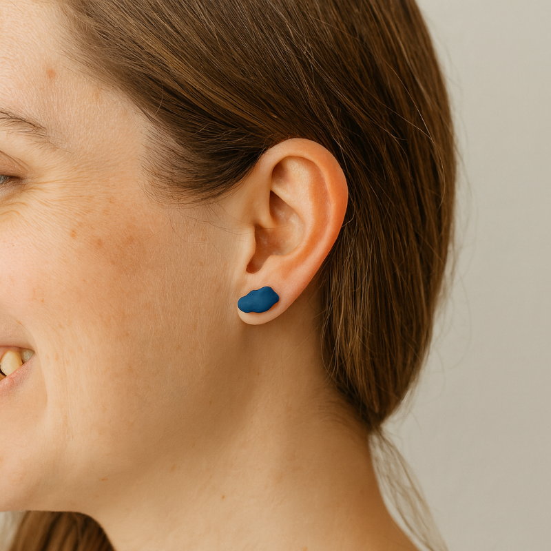 Close-up of cobalt blue porcelain cloud stud earrings on model