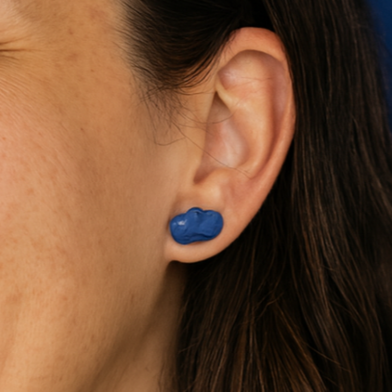 Close-up of cobalt blue porcelain cloud stud earrings on model