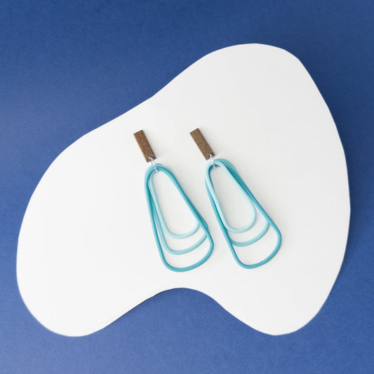 Bold teal dangles that capture the depth and energy of the ocean in every movement.